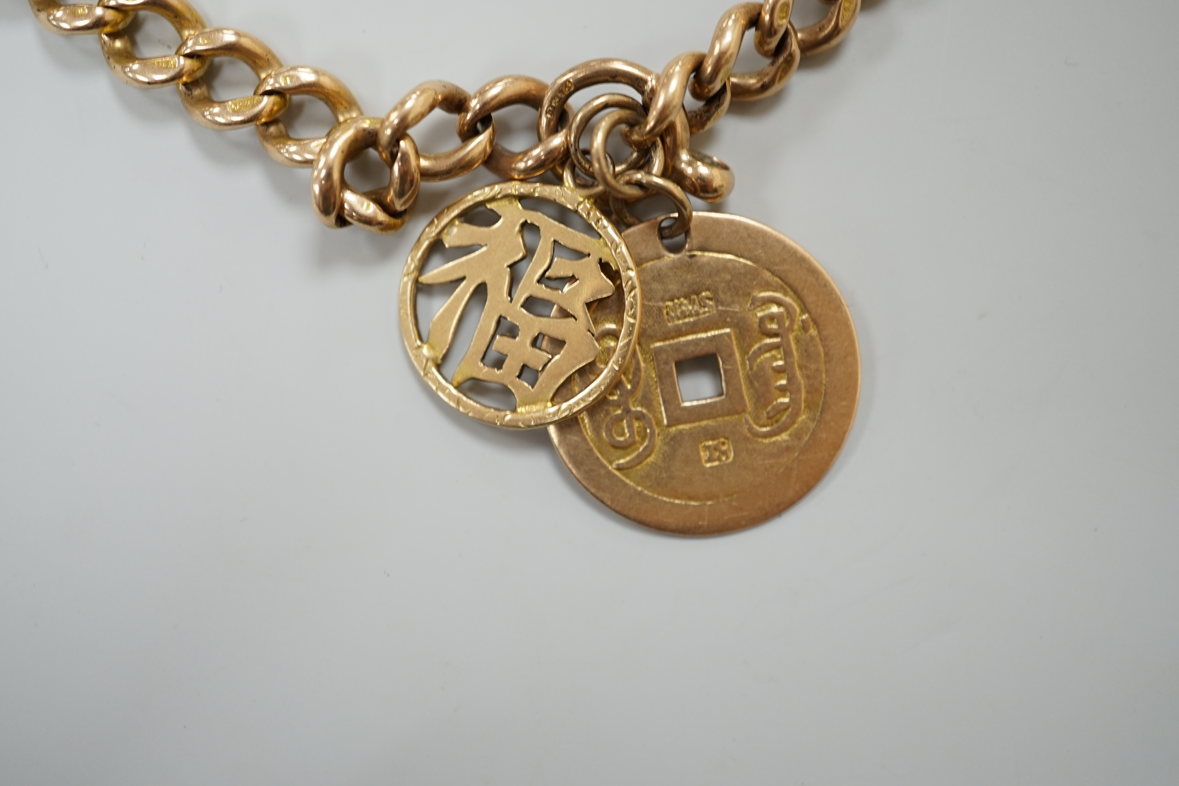 A 15ct gold link marked curblink bracelet, with pierced Chinese 18K coin charm, and an unmarked Chinese character charm, gross 36.7 grams